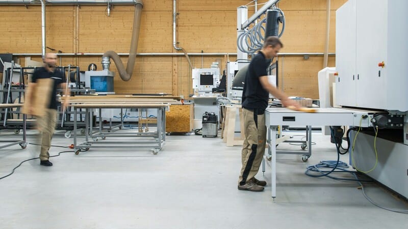 Man working inside while standing at a table.