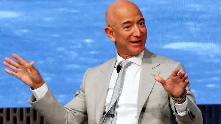 Jeff Bezos in a white suit talking on stage.
