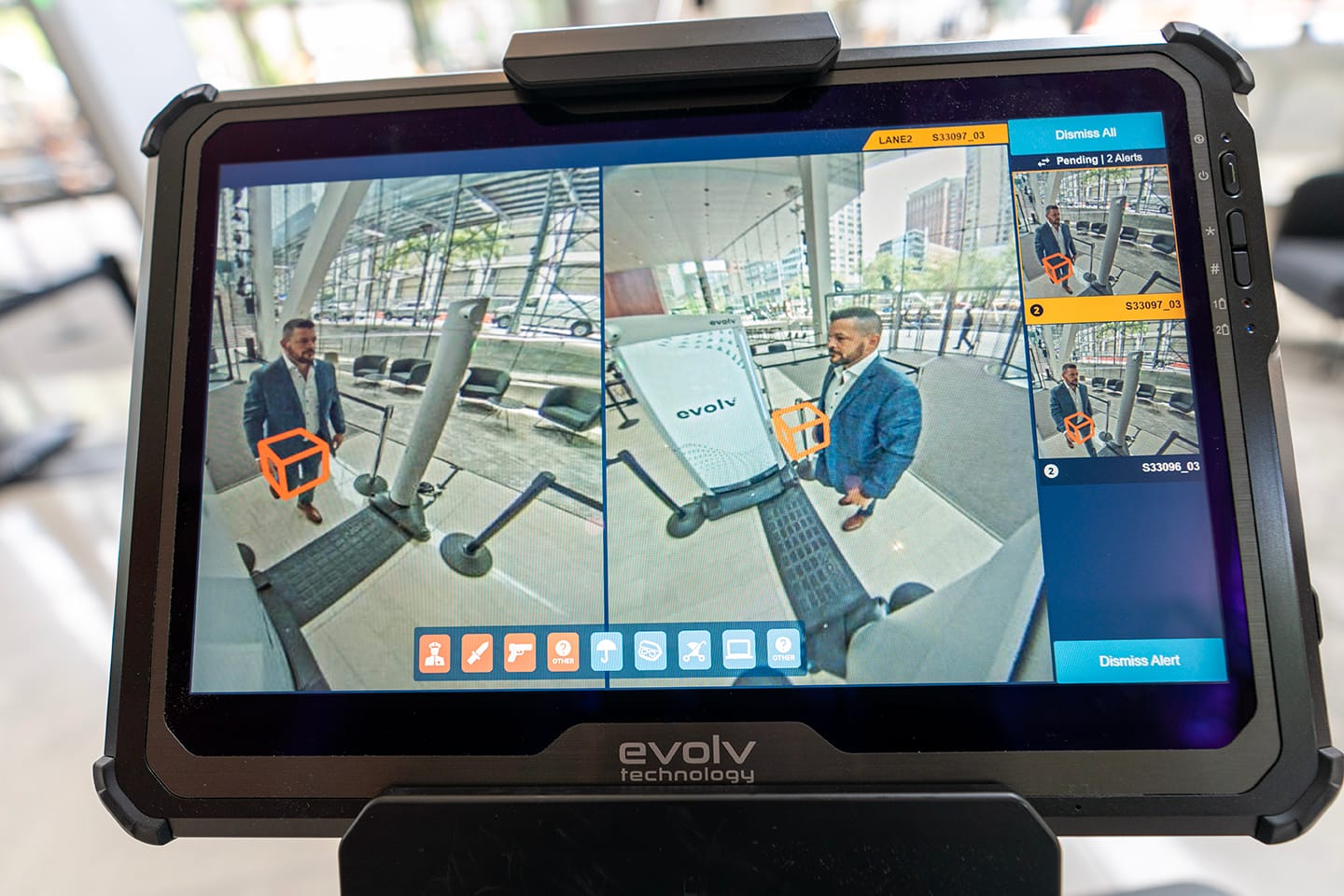 Screen showing man walking through checkpoint. A box is placed over a suspected firearm being detected.