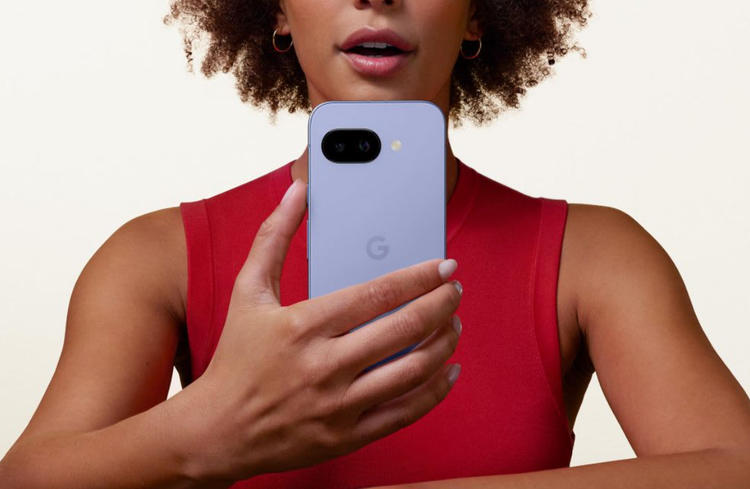 Woman in sleeveless red shirt holding the Google Pixel 9a.